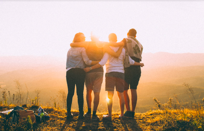 group of friends embracing and looking at nature view