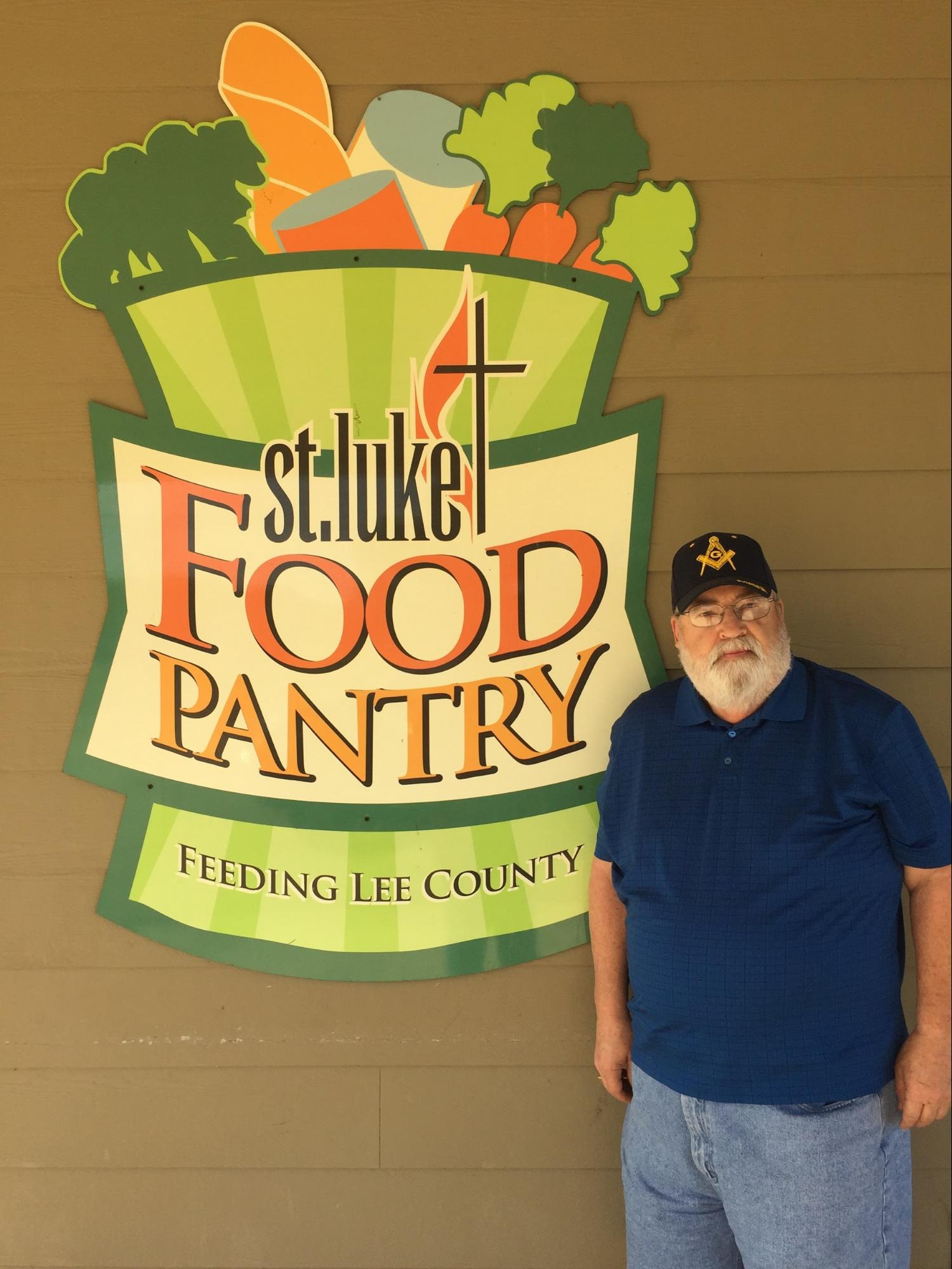 Man in front of St. Luke Food Pantry